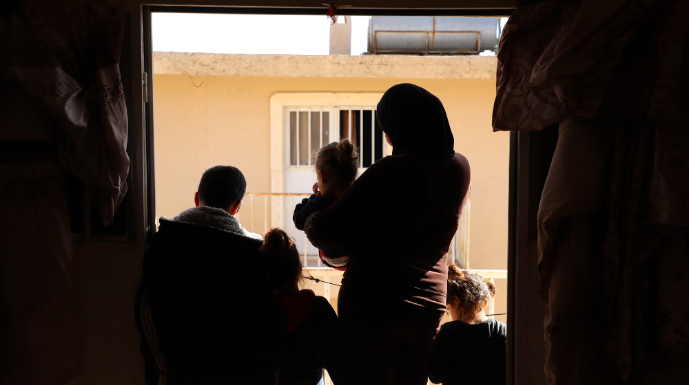 Una mujer y sus hijos en la puerta de un refugio.