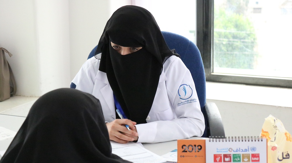  Une conseillère psychosociale parle avec une femme, à un bureau.