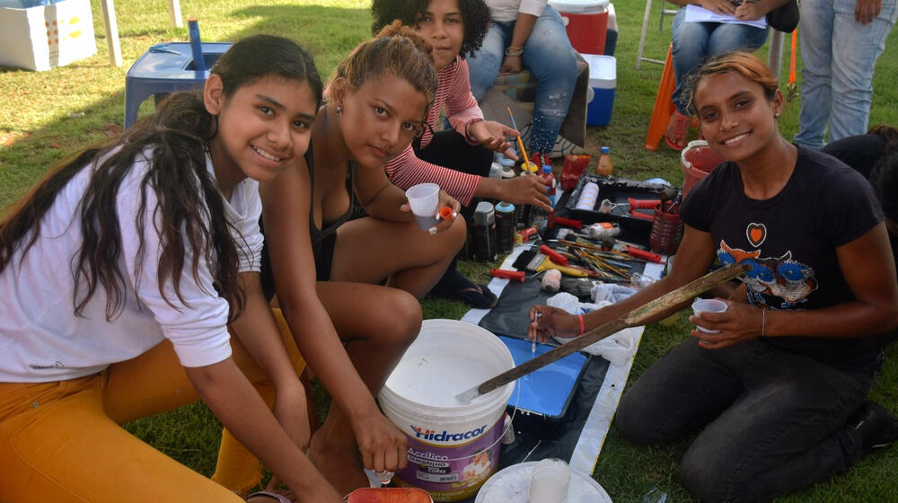 A group of girls mix paint.