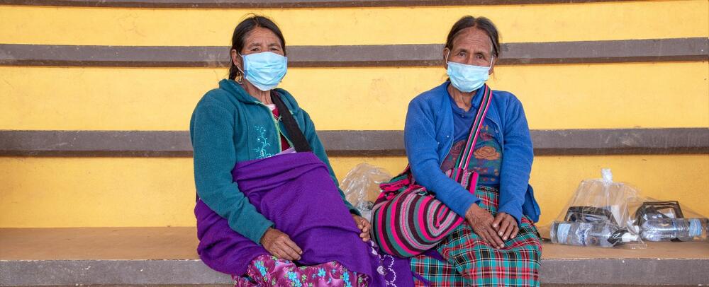 Two older women sit together. 