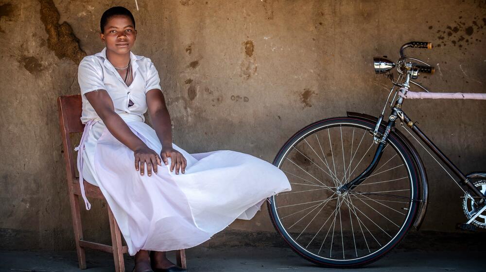 Una mujer se sienta con una bicicleta.