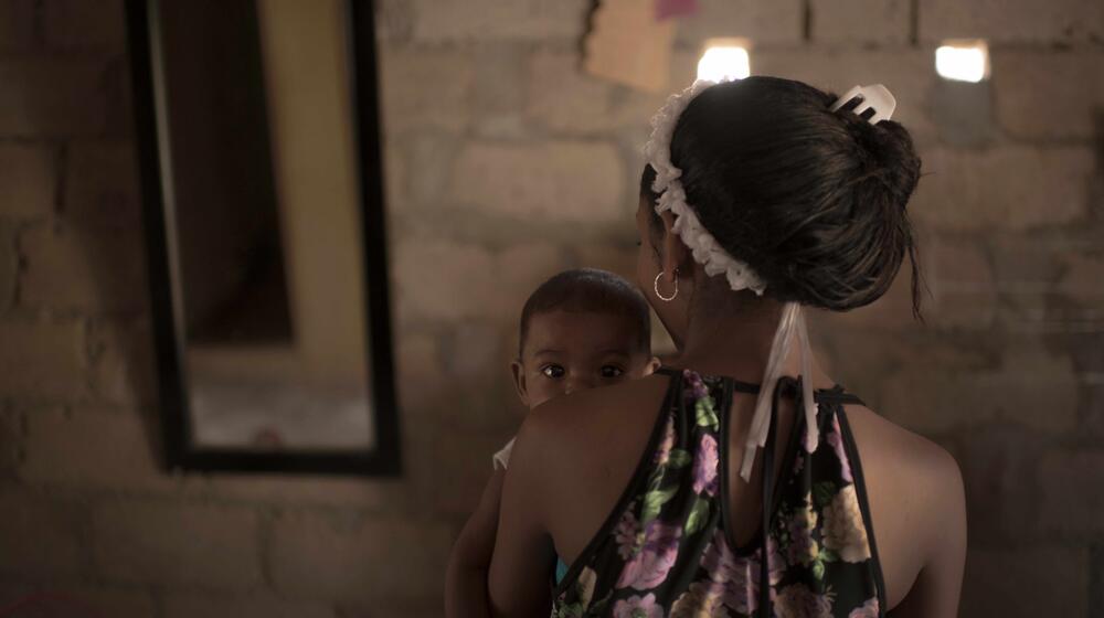 A woman holds a baby,