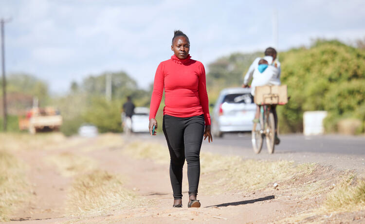 Una mujer camina a lo largo de una carretera