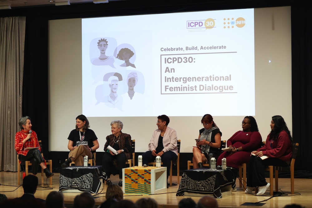 A group of panelists are seated on stage. 