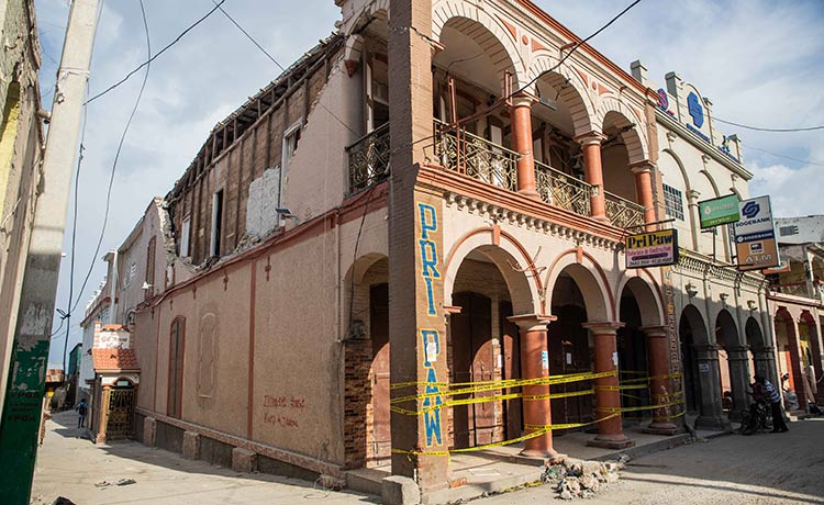 A damaged building is wrapped in yellow "caution" tape.