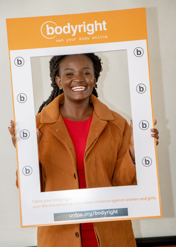 A young woman holds a bodyright poster