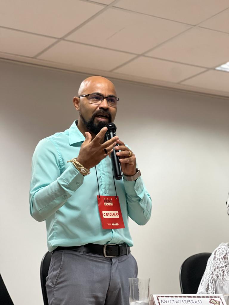 A man stands and speaks into a microphone.