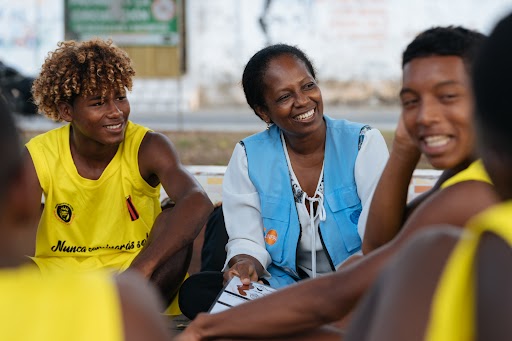 Un grupo de personas, incluido un trabajador del UNFPA, se sientan juntas.