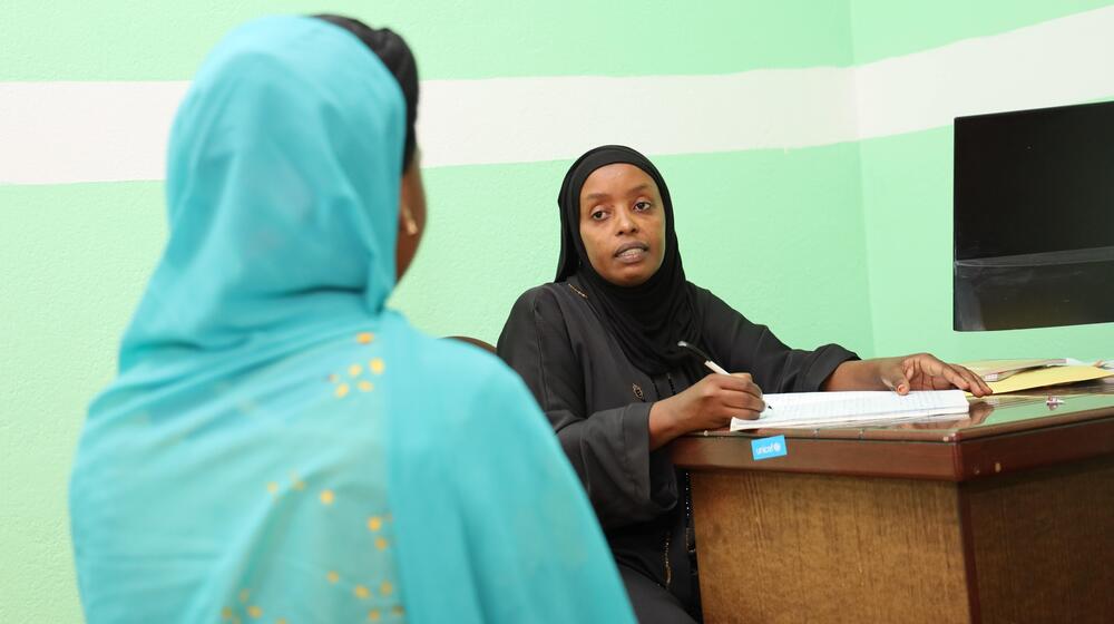 A woman talks with a healthcare worker.