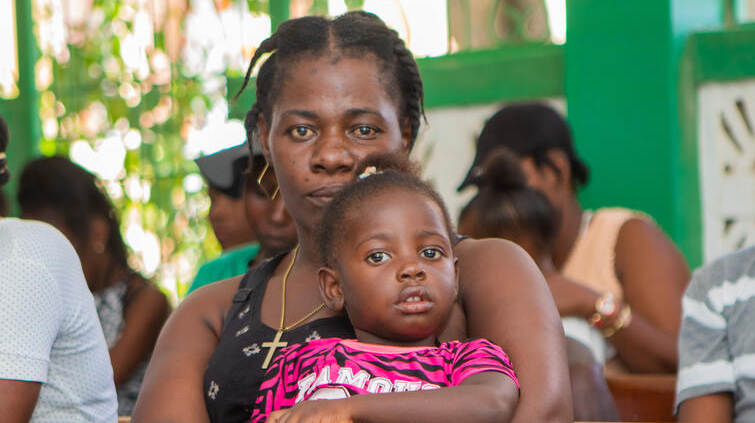 A woman holds her child.