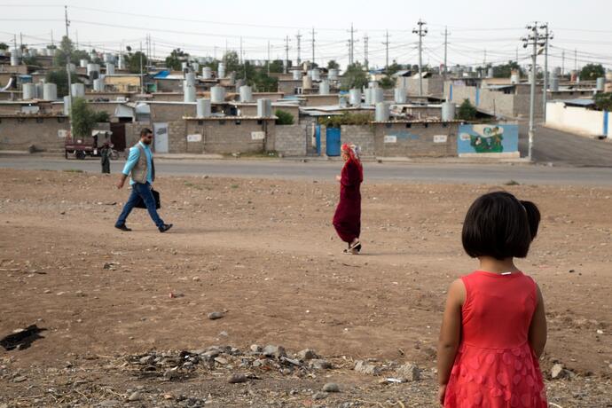 A young girl looking towards a city. 