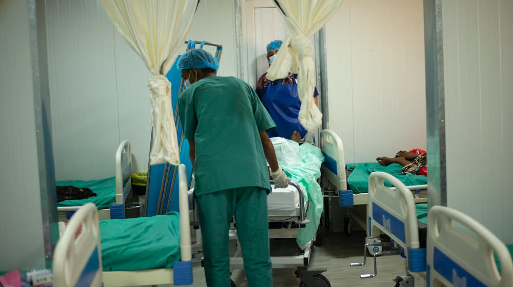 Health workers wheel a patient into a maternity ward.