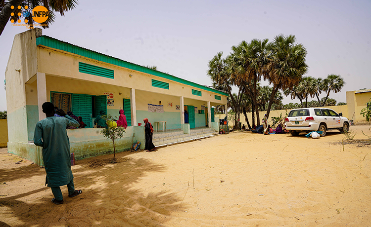  A one-story building is framed by palm trees.