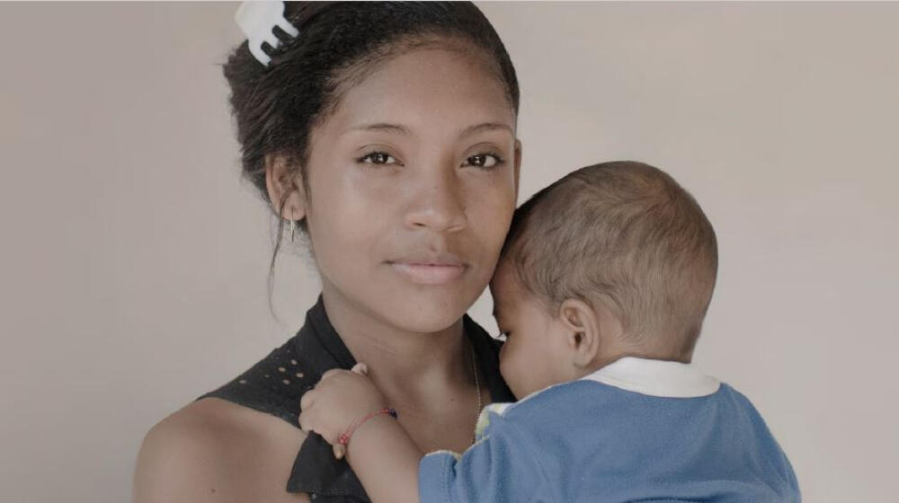 A girl holds a baby.