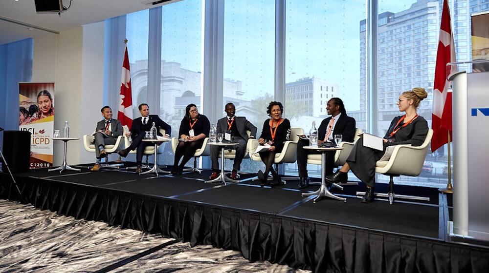 A group off parliamentarians and experts are seated on stage at the 2018 International Parliamentarians’ Conference on the Implementation of the ICPD Programme of Action.