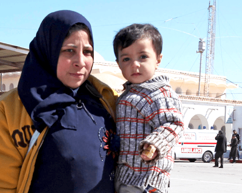 A pregnant Libyan refugee with her son.