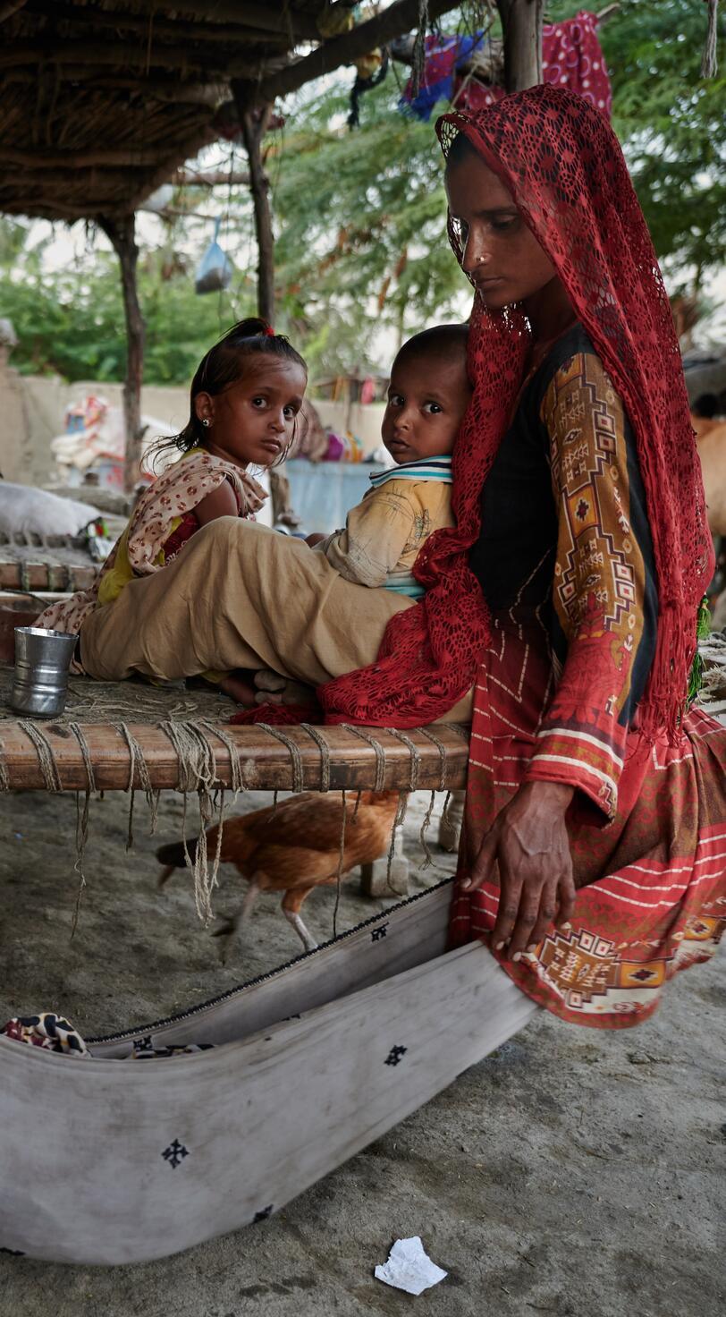 A mother tends to a baby in a hammock.