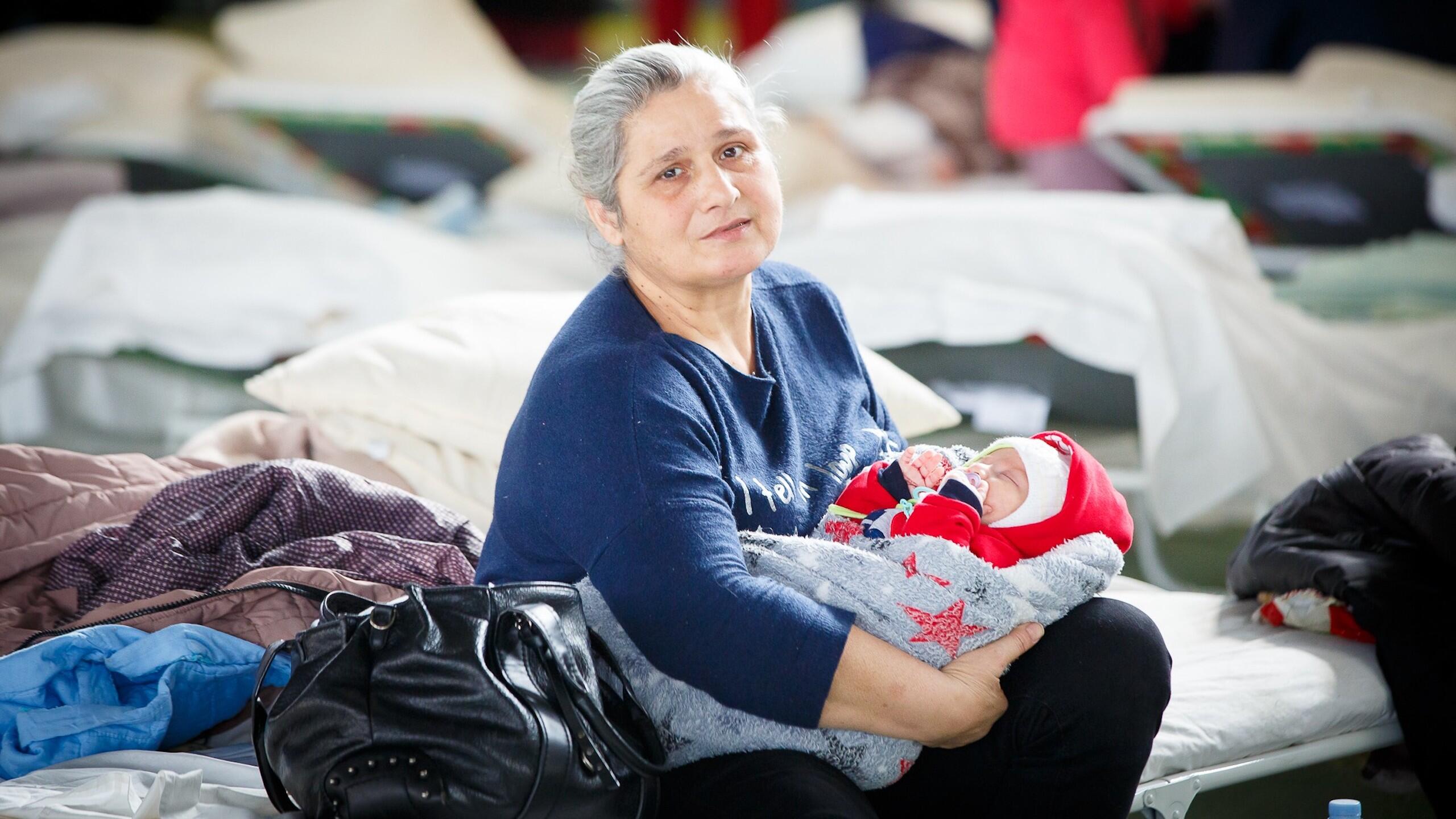 A grandmother holds her infant grandchild. 