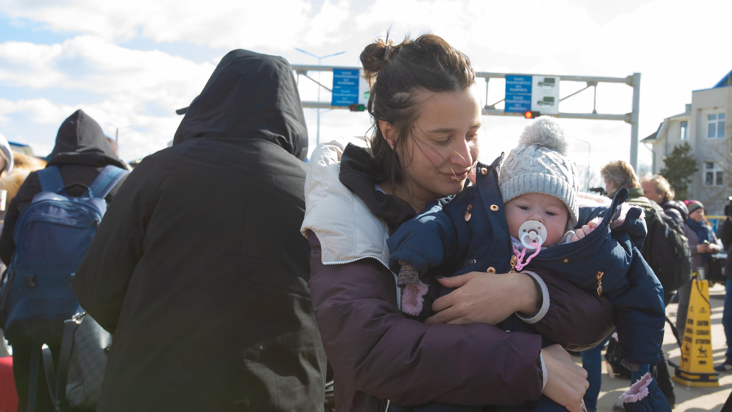 A mother holds her young child. 