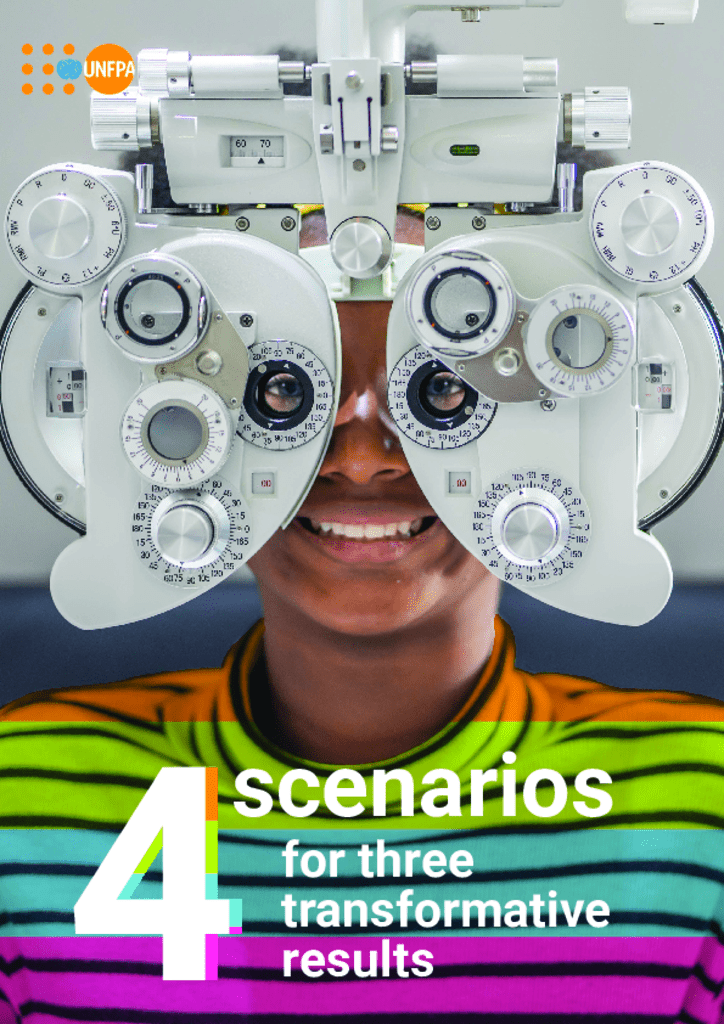 women peering through Optometrist's eye device. She wears a rainbow T-shirt and smiles