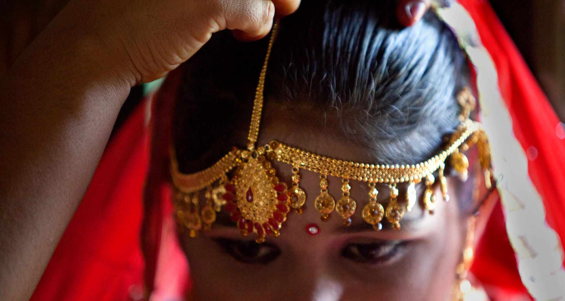 Une jeune fille est vêtue de bijoux.